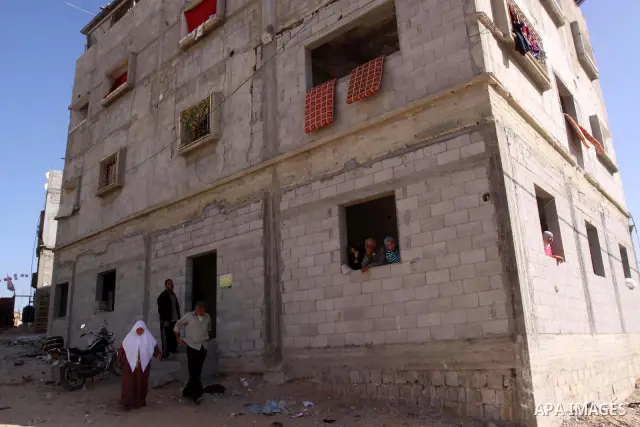 Palestinians stand in front of their house which was reconstructed by the Islamic Conference Organization in the northern Gaza Strip, on Dec. 1,2010. Islamic Conference Organization reconstruction 400 house which were de...