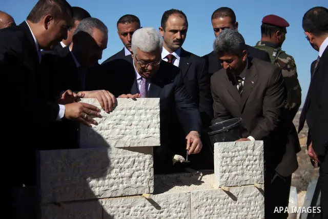 Palestinian president Mahmud Abbas lays cement on the stones of a new building that will be used as a diplomatic compound for the Palestinian Authority in the West bank village of Surda, north of Ramallah 01 December 201...
