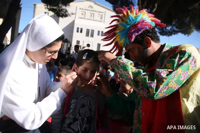 Christians students take part during a rally in front of the Church of the Nativity as they prepare for christmas, believed to be by Christians the birthplace of Jesus Christ, in the West Bank city of Bethlehem on Decemb...