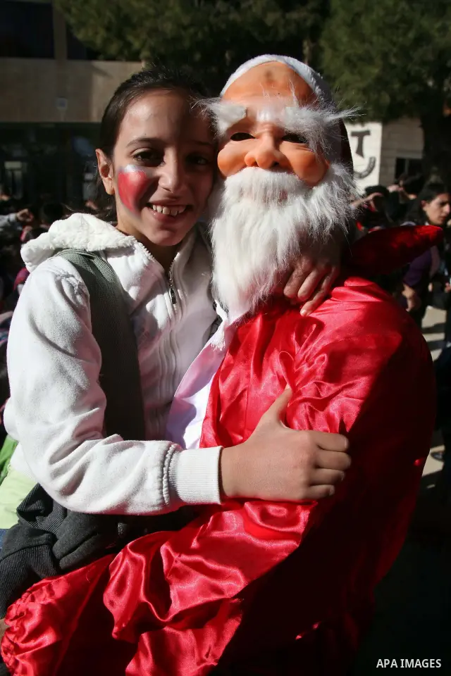 Christians students take part during a rally in front of the Church of the Nativity as they prepare for christmas, believed to be by Christians the birthplace of Jesus Christ, in the West Bank city of Bethlehem on Decemb...