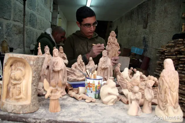 A Palestinian carver works on wooden figurines at the Giacaman Olive Wood factory next to the Church of the Nativity in the West Bank town of Bethlehem, on 06 December 2010. The traditionally accepted birthplace of Jesus...