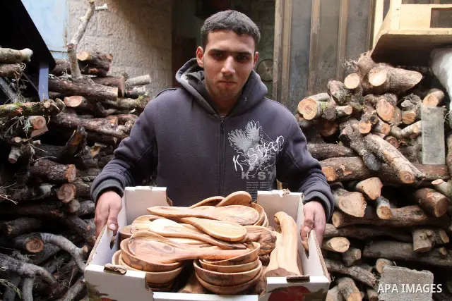 A Palestinian carver works on wooden figurines at the Giacaman Olive Wood factory next to the Church of the Nativity in the West Bank town of Bethlehem, on 06 December 2010. The traditionally accepted birthplace of Jesus...