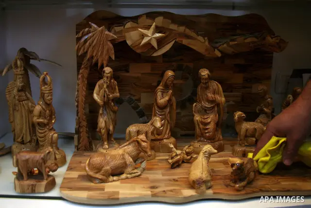 A Palestinian carver works on wooden figurines at the Giacaman Olive Wood factory next to the Church of the Nativity in the West Bank town of Bethlehem, on 06 December 2010. The traditionally accepted birthplace of Jesus...