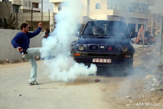 African National Congress members, Palestinian, International and Israeli protesters run for cover as Israeli soldiers throw a stun grenade and fire tear gas during a protest against the controversial Israeli barrier in...