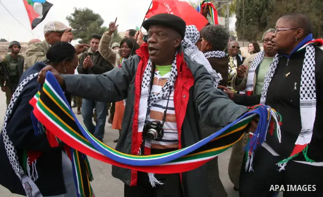 African National Congress members, Palestinian, International and Israeli protesters take part in a protest against the controversial Israeli barrier in the West Bank village of al-Masarah, near Bethlehem, December 10, 2...