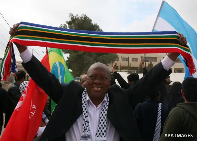 African National Congress members, Palestinian, International and Israeli protesters take part in a protest against the controversial Israeli barrier in the West Bank village of al-Masarah, near Bethlehem, December 10, 2...