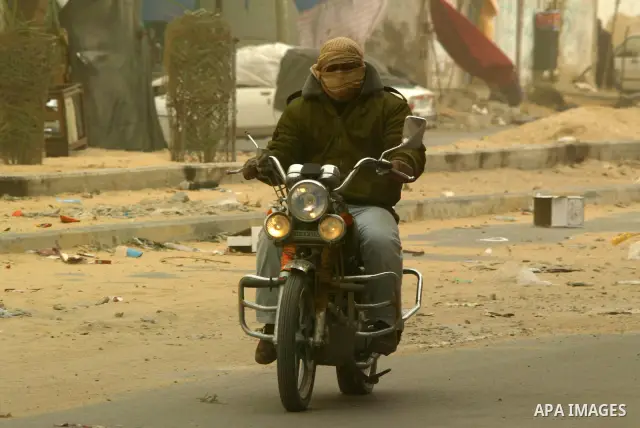 A Palestinian youth rides his motorcycle during cold winds and sand storms in the southern Gaza Strip town of Rafah on Dec. 12,2010. Photo by Abed Rahim Khatib