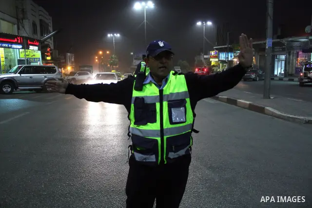 A Palestinian policeman organizes the traffic during heavy rain and cold winds in the West Bank city of Hebron on December 12, 2010. Photo by Najeh Hashlamoun