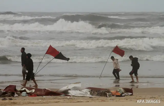 Palestinians walk on the beach during cold winds and sand storms in Gaza City on Dec. 13,2010. Photo by Ashraf Amra