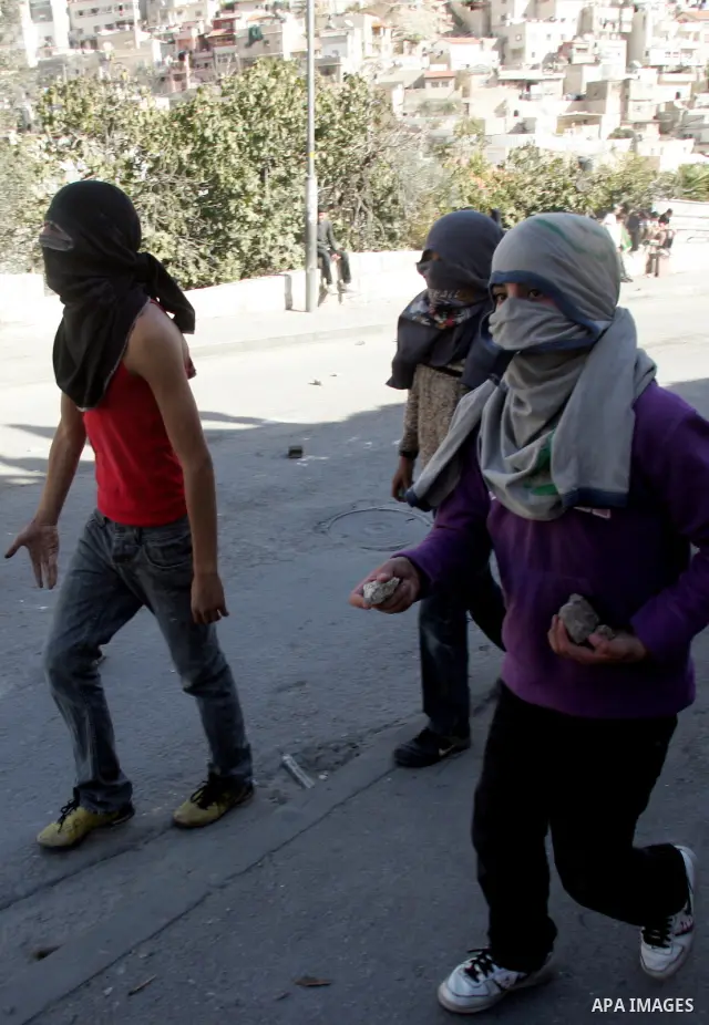 Palestinian youths throw stones at Israeli security forces during a protest after the weekly Friday prayers on December 17, 2010 in the Arab east Jerusalem neighbourhood of Silwan against Jewish settlement in Palestinian...