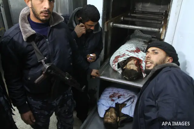 Palestinian security officers look at the body of a Palestinian killed during an Israeli attack, at the morgue of al-Aqsa hospital in Deir al Balah center Gaza strip on December 19, 2010. Five Palestinians were killed as...