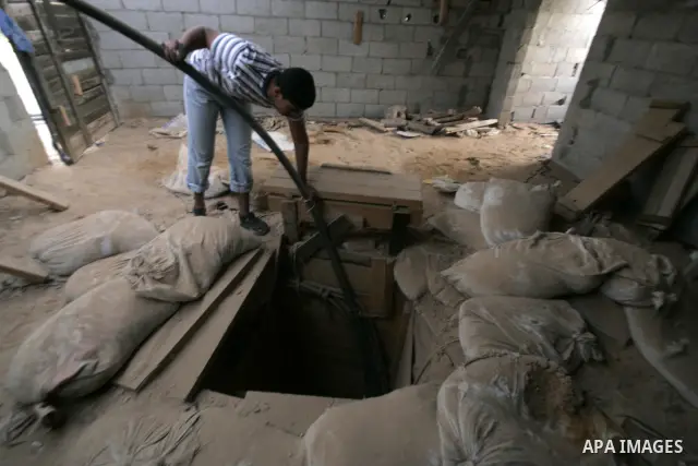 A Palestinian man smuggles diesel through a tunnel in the southern Rafah refugee camp along Egypt's border with the Gaza Strip on December 20, 2010. A Hamas official in Gaza announced that the Islamist movement which run...