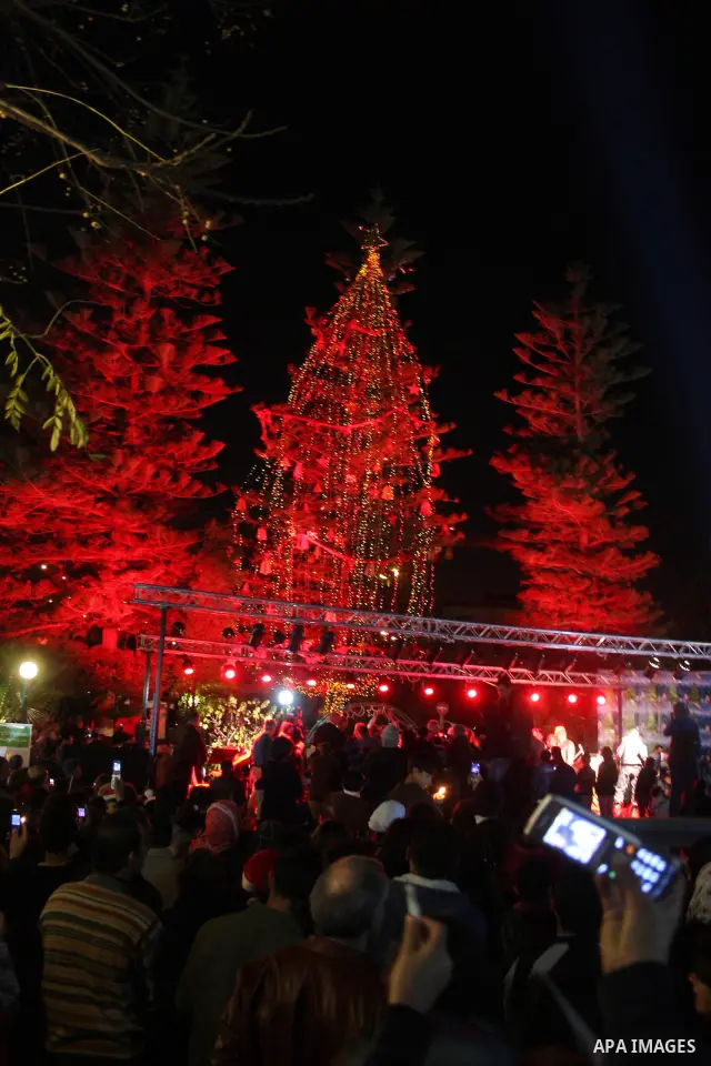 Palestinians take part in the Christmas tree lighting ceremony in the West Bank city of Ramallah, Monday, Dec. 20, 2010. Photo by Issam Rimawi