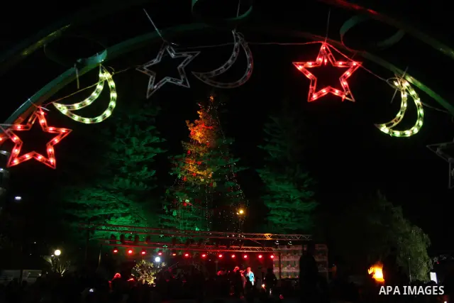 Palestinians take part in the Christmas tree lighting ceremony in the West Bank city of Ramallah, Monday, Dec. 20, 2010. Photo by Issam Rimawi