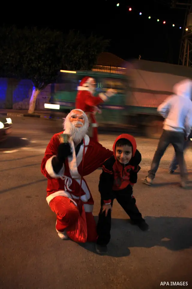 Palestinians wearing Santa Claus costumes prepare for Christmas outside a church in Rafidia near the West Bank town of Nablus, 21 December 2010. Photo by Wagdi Eshtayah