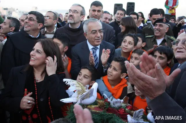Palestinian Prime Minister Salam Fayyad takes part during a Christmas parade in the West Bank city of Bethlehem on 23 December 2010. Scores of Christian pilgrims are preparing to gather in the traditional birthplace of J...