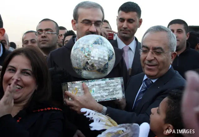 Palestinian Prime Minister Salam Fayyad takes part during a Christmas parade in the West Bank city of Bethlehem on 23 December 2010. Scores of Christian pilgrims are preparing to gather in the traditional birthplace of J...