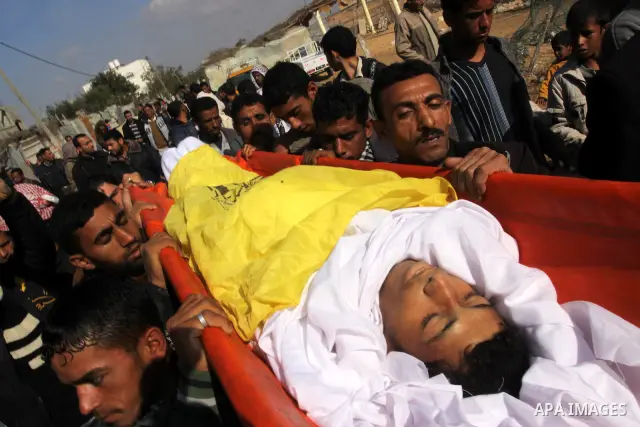 Palestinian mourners carry the body of Salama Abu Hashish, 22, during his funeral in Umm Nasser, in the northern Gaza Strip , Friday, Dec. 24, 2010. A Palestinian medic said Abu Hashish was leading his goats in an open a...