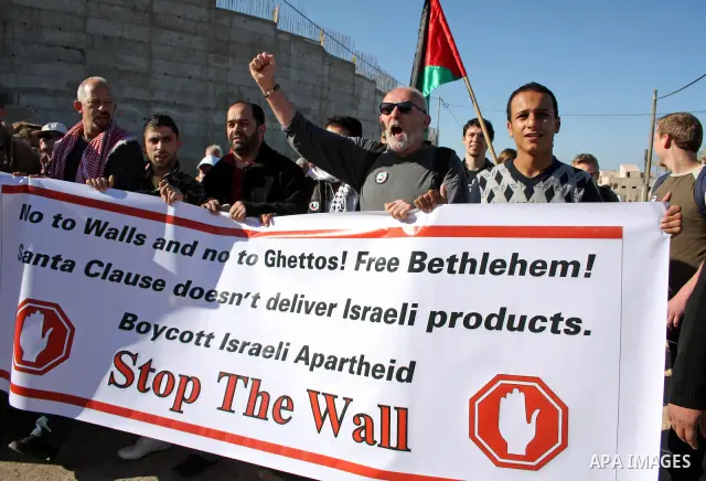 Palestinian and foreign demonstrators take part in a protest against Israel's controversial separation barrier in the West Bank village of Walajah near the biblical town of Bethlehem on 24 December 2010.. Photo by Najeh...