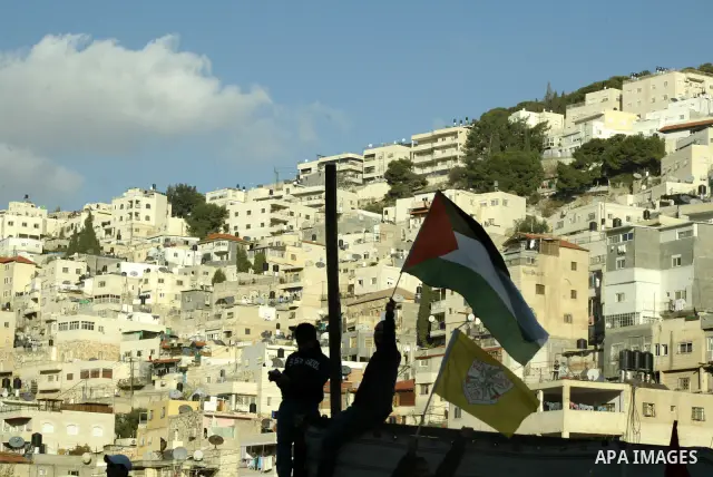 The Palestinian flag is held up as Israeli, Palestinian and foreign activists hold a demonstration in the Arab east Jerusalem neighbourhood of Silwan against Jewish settlement activity in the Palestinian districts of the...