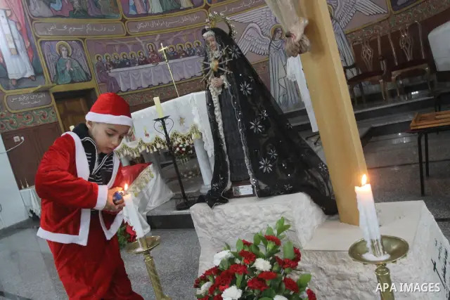 A Palestinian boy dressed up as Santa Claus lights a candel during Christmas eve mass in Gaza City, on December 24, 2010, a Christians around the world celebrate the birth of jesus Christ. Photo by Mohammed Asad