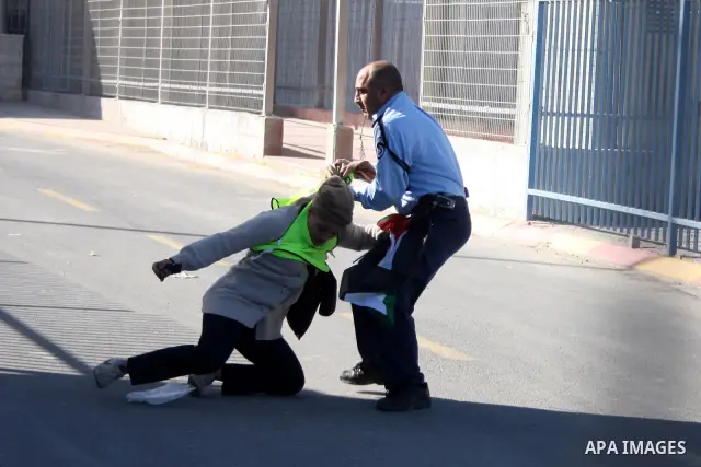 Israeli policemen detain a protester during a protest against Israel's separation barrier at the Qalandia checkpoint between Ramallah and Jerusalem, Sunday, Dec. 26, 2010. Israel says the barrier is necessary for securit...