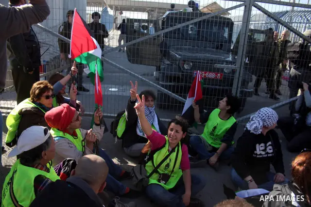 Palestinian and foreign activists protest against the Israel's separation barrier at the Qalandia checkpoint between Ramallah and Jerusalem, Sunday, Dec. 26, 2010. Israel says the barrier is necessary for security while...