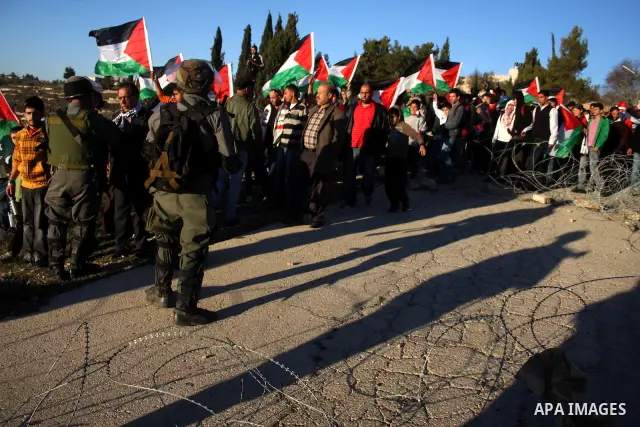 Palestinians and foreigners take part in a protest against the closure of Beit Eil checkpoint in the village of Buteen near the West Bank city of Ramallah on Dec. 27, 2010. Photo by Issam Rimawi