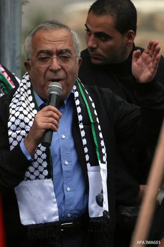Palestinian Prime Minister, Salam Fayyad take part in a protest against Israel's separation barrier outside the West Bank village of Bilin, near Ramallah, Friday, Dec 31, 2010. Israel says the barrier is necessary for se...