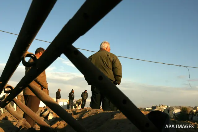 Palestinians stand next to a crater following an Israeli air strike on a smuggling tunnel in Rafah, on the border between Egypt and southern Gaza Strip, Wednesday, Jan. 5, 2011. Photo by Abed Rahim Khatib
