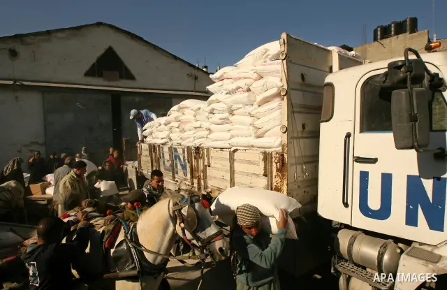 Palestinians receive food aid from the United Nations Relief and Works Agency (UNRWA) at the refugee camp of Rafah in the southern Gaza Strip on January 13, 2011. The UN distribution center is one of many in the Gaza str...