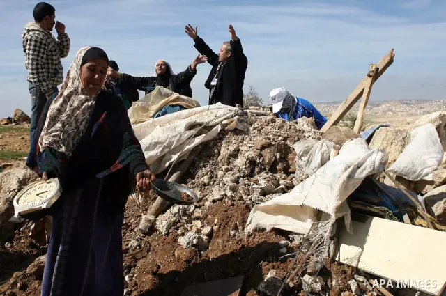 A Palestinian woman weeps as she and her family try to retrieve items from the rubble of his family house after it was destroyed by Israeli army tractors early on 22 February 2011 in the West Bank village of Yatta near H...