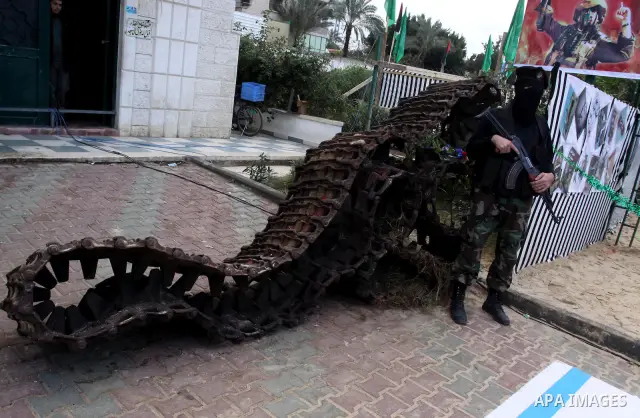 A Palestinian Hamas militant stands in front of parts of a tank during a rally marking the 2nd anniversary of Israeli war on Gaza Strip, in Gaza City on January 1, 2011. Photo by Mohammed Asad