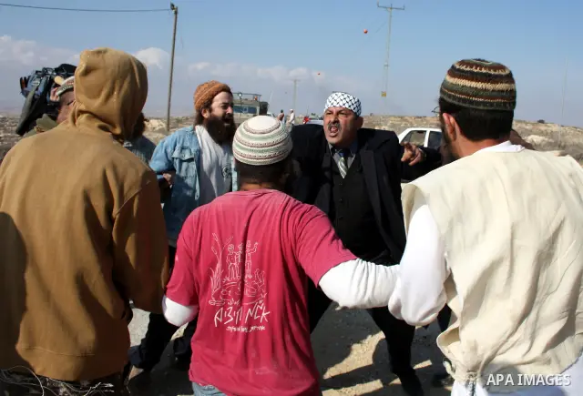A Palestinian man scuffles with Jewish settlers as he try to evacuate them from Palestinian land near the village of Yatta, south of the West Bank city of Hebron on Jan. 2, 2011. Photo by Najeh Hashlamoun