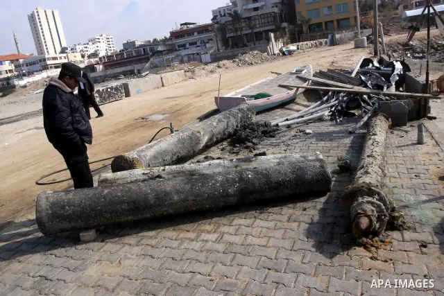 A Member of Palestinian naval policemen stands near an ancient columns older than 1300 years belonging to palace from the Roman era in the port of Gaza City on Dec. 3,2010. Photo by Mohammed Asad