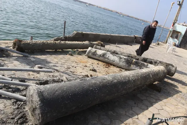 A Member of Palestinian naval policemen walks near an ancient columns older than 1300 years belonging to palace from the Roman era in the port of Gaza City on Dec. 3,2010. Photo by Mohammed Asad