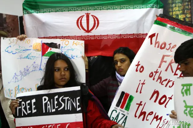 Members of the Asia 1 aid convoy holds placards during a rally at the ministry of prisoners in Gaza City on Jan. 3,2011. About 170 activists from over 15 Asian states crossed early Monday from Egypt into Gaza through Raf...