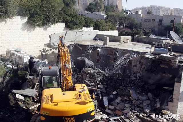 An Israeli bulldozer destroys a Palestinian house in the Sheikh Jarrah neighbourhood of East Jerusalem January 3, 2011. The house was destroyed by Israeli municipality bulldozers for allegedly being built without a permi...