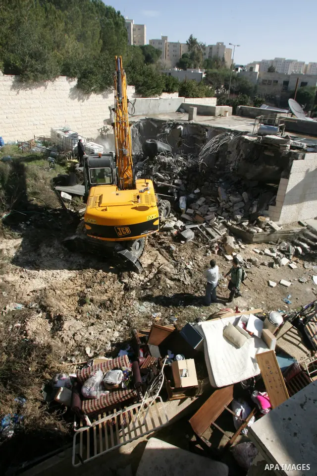 An Israeli bulldozer destroys a Palestinian house in the Sheikh Jarrah neighbourhood of East Jerusalem January 3, 2011. The house was destroyed by Israeli municipality bulldozers for allegedly being built without a permi...