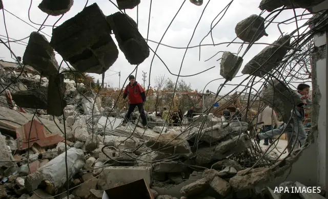 Palestinians stand on the rubble of a home after Israeli army bulldozers destroyed the house in the Arab neighborhood of Beit Hanina in occupied east Jerusalem on on Jan 4, 2011. Photo by Mahfouz Abu Turk