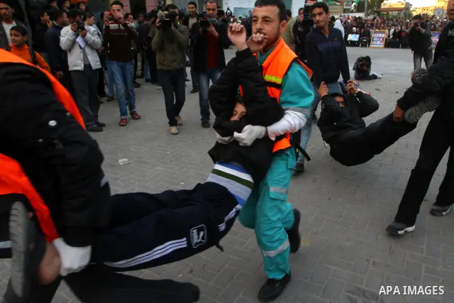 Palestinian youths act as mock injured as they take part in a rally organised by Hamas marking the second anniversary of the Israel-Gaza war in the Jabalia refugee camp in the northern Gaza Strip on January 6, 2011. Phot...