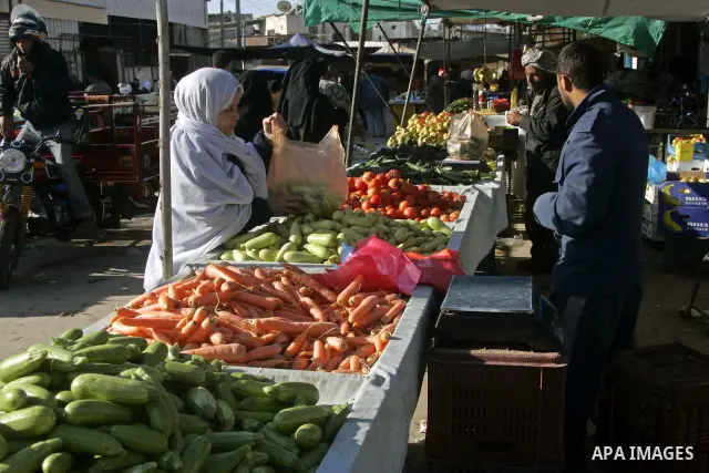 A Palestinian woman buys vegetable at a market in southern Gaza town of Rafah on January 10, 2011. Photo by Abed Rahim Khatib