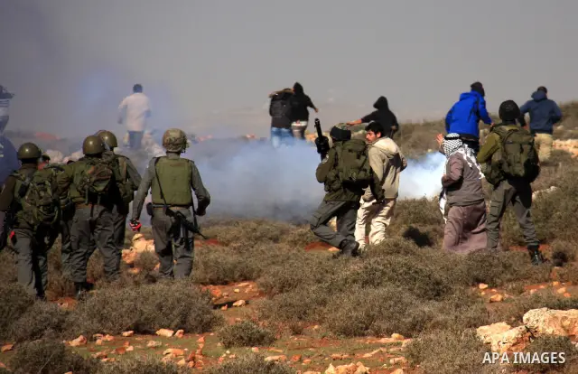 Israeli soldiers use teargas to disperse Palestinians during a clash between Jewish settlers and Palestinians over farming land between the Jewish settlement Shiloh and the West Bank the village of Qusrah near Nablus, Th...