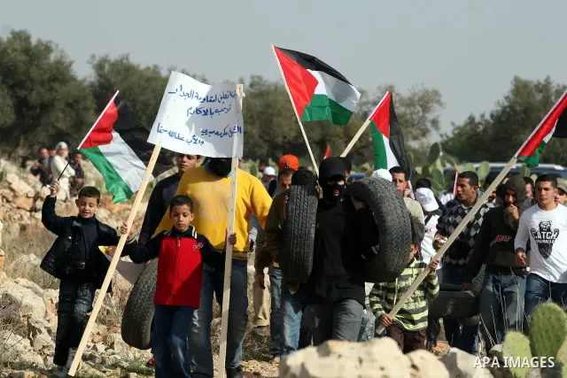 Palestinian demonstrators take part in a protest against Israel's separation barrier in the West Bank village of Nilin near Ramallah, Friday, Jan. 14, 2011. Photo by Issam Rimawi