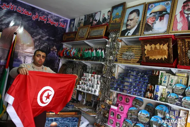 A Palestinian vendor displays a Tunisian flag in his shop , in Gaza City on Jan. 15, 2010. Tunisia's Speaker of Parliament Foued Mbazaa took power on today amid chaotic scenes in the streets of the capital after Presiden...