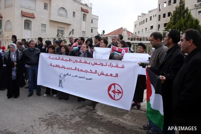 Palestinian demonstrators take part in a protest in solidarity with the Tunisian people in front of the Tunisian Embassy in the West Bank city of Ramallah January 15, 2011. The protest confirmed that the two peoples, Pal...