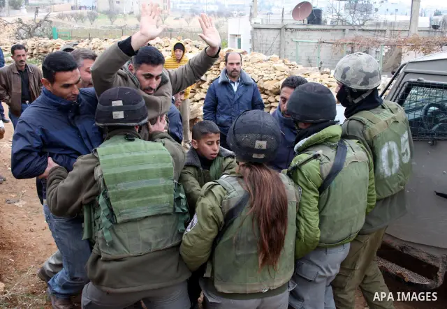 Israeli soldiers stand guard during a demonstration by Palestinian, Israeli and foreign activists against the demolishing of farm land to be used in the construction of Jewish settlements near the existing Israeli settle...