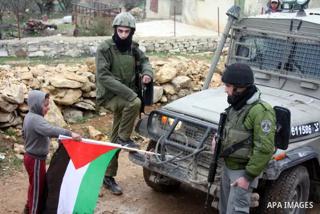 Israeli soldiers stand guard during a demonstration by Palestinian, Israeli and foreign activists against the demolishing of farm land to be used in the construction of Jewish settlements near the existing Israeli settle...