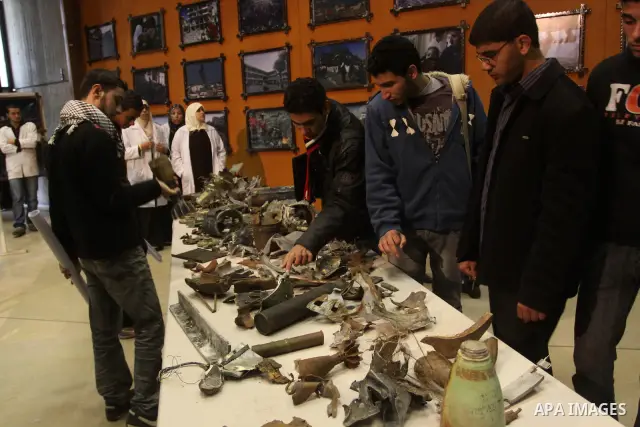 Palestinians look at the remains of the ammunition which was used during the war on Gaza at an exhibition organized by Palestinian High Commission marks the second anniversary of Israel's three-week offensive on Gaza, at...