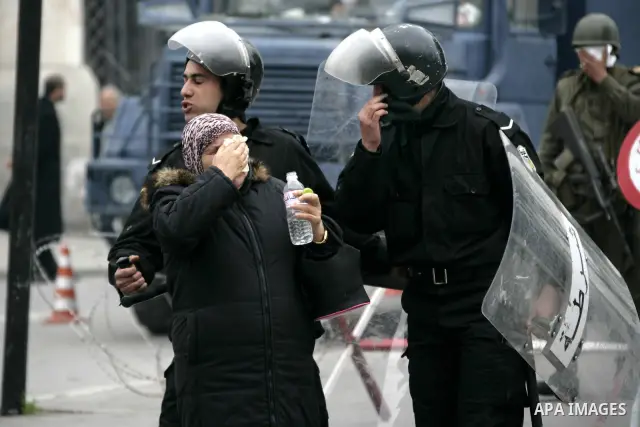 A Tunisian woman tries to protect herself from tear gas as protests still going on in Tunis 4 days after the Depature of the Tunisian President Zine El Abidine Ben Ali to Saudi Arabia, Tunisia, 18 January 2011. Tunisian...